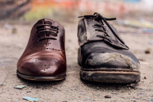 Concept of rich and poor in person. gepflegte vs. ungepflegte Schuhe bei der Arbeit